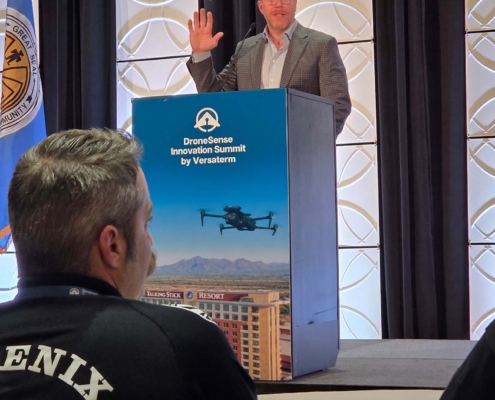 Speaker delivering a keynote presentation during the DroneSense Innovation Summit by Versaterm as public safety professionals attend the conference.