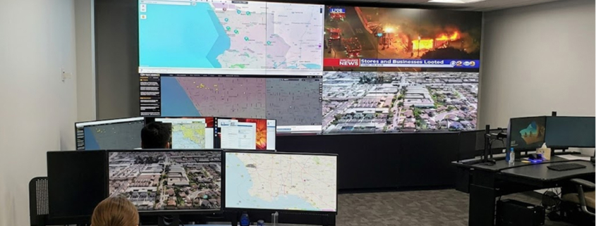 Flying Lion remote pilot monitoring live drone feeds and maps inside a Real-Time Crime Center supporting 24/7 Drone as First Responder operations